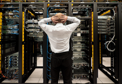 man with hands on head standing in front of computer room